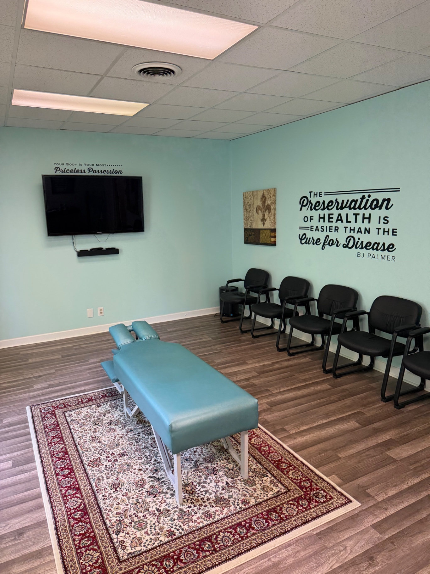 Chiropractic treatment room with adjusting table and teal walls