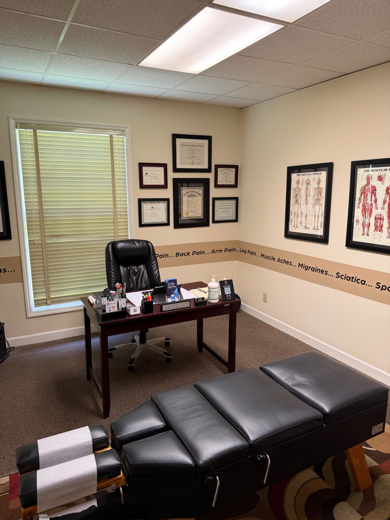 Office desk, diplomas and anatomy posters at Total Health Chiropractic